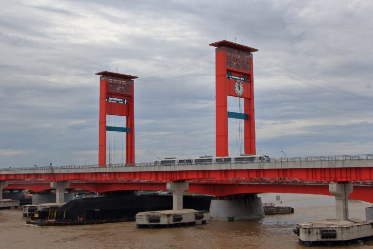 LRT Palembang melintas di samping Jembatan Ampera di atas Sungai Musi