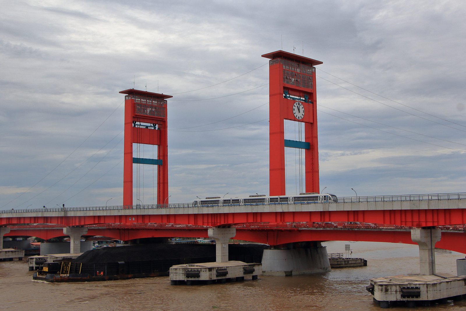 LRT Palembang melintas di samping Jembatan Ampera di atas Sungai Musi
